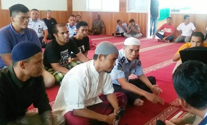Salah seorang warga binaan Lapas Bukittinggi, Rudianto (peci abu-abu) saat dibimbing membaca kalimat syahadat, Senin (20/1/2020). (ANTARA/Ira Febrianti)