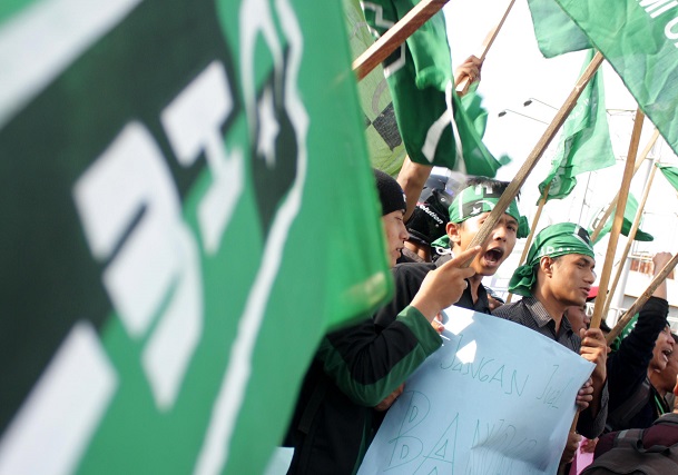 Puluhan anggota Himpunan Mahasiswa Islam (HMI) mengibarkan bendera/FOTO ANTARA/Irwansyah Putra.