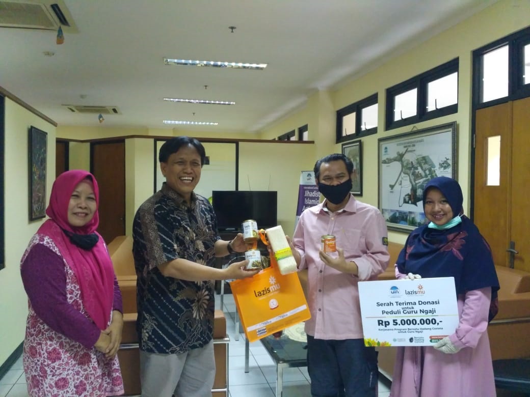 Dekan FIDKOM UIN Jakarta,  Dr. Suparto menyerahkan bantuan melalui Rizaludin Kurniawan, Anggota Badan Pengurus Lazismu Pusat