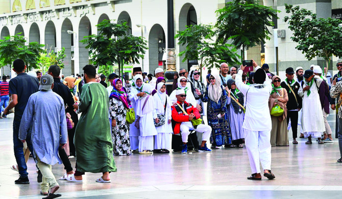 Sekelompok pengunjung umrah berpakaian tradisional yang kehadirannya di Makkah dan Madinah bertepatan dengan Idul Fitri terlihat berfoto untuk memperingati hari tersebut. (SPA)