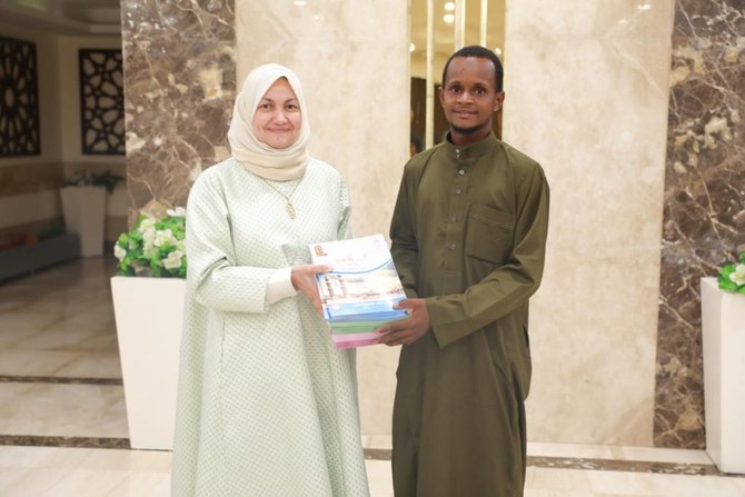 Mamadou Safayou Barry, seorang mahasiswa asal Guinea, yang bersepeda dari negara asalnya ke Mesir untuk belajar di Al-Azhar Al-Sharif, bersama Dr. Nahla Elseidy, penasihat urusan ekspatriat di universitas tersebut. (Dok)