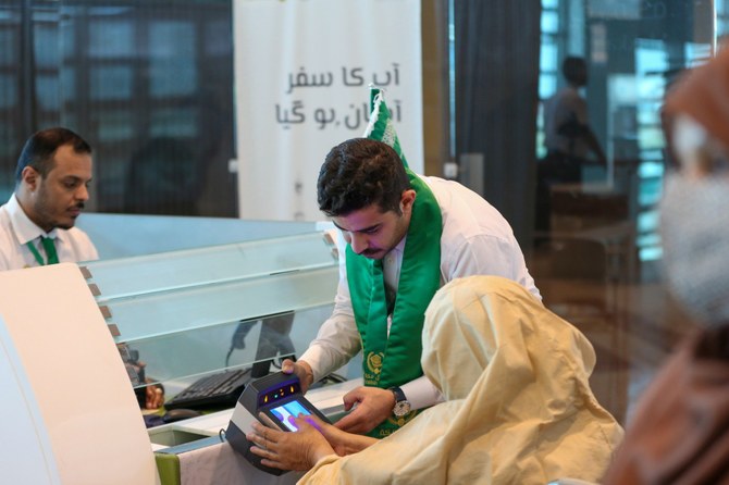 Dalam foto file ini, diambil pada 13 Juni 2023, seorang pejabat Saudi memfasilitasi jamaah haji Pakistan selama biometrik di konter imigrasi di konter Rute Makkah yang didirikan di Bandara Internasional Islamabad.(X/@MakkahRoute)