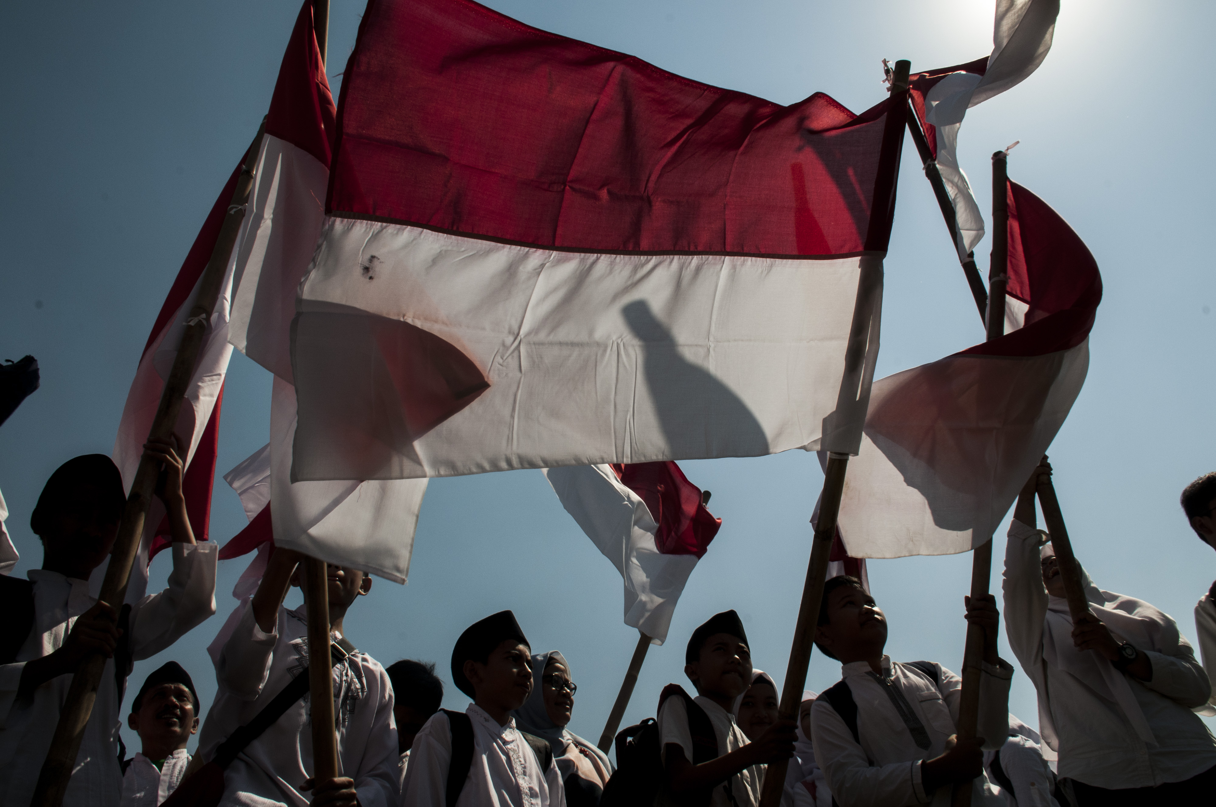 Sejumlah santri membawa bendera merah putih saat mengikuti upacara Peringatan Hari Santri Nasional Tingkat Provinsi Jawa Barat 2019 di Lapangan Gasibu, Bandung, Jawa Barat, Senin (22/10/2019)/ANTARA FOTO/Novrian Arbi